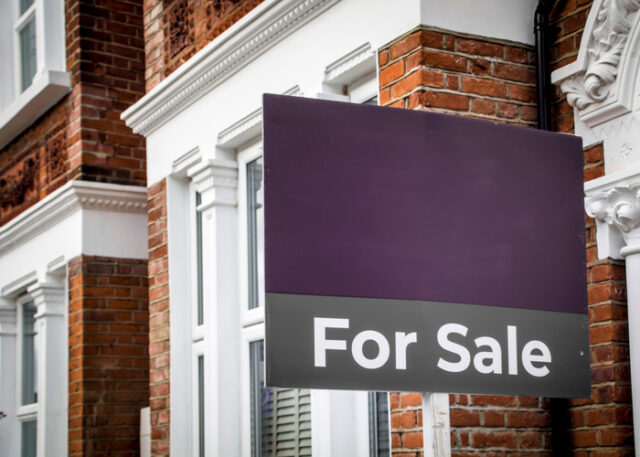 Purple for sale sign outside a home