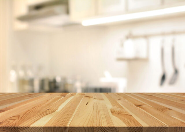 Wooden kitchen island with blurred kitchen in the background