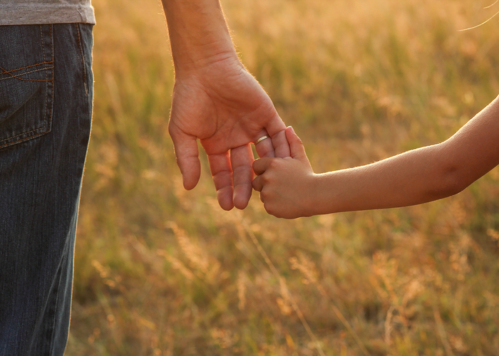 Close-up of a parent holding a child’s hand