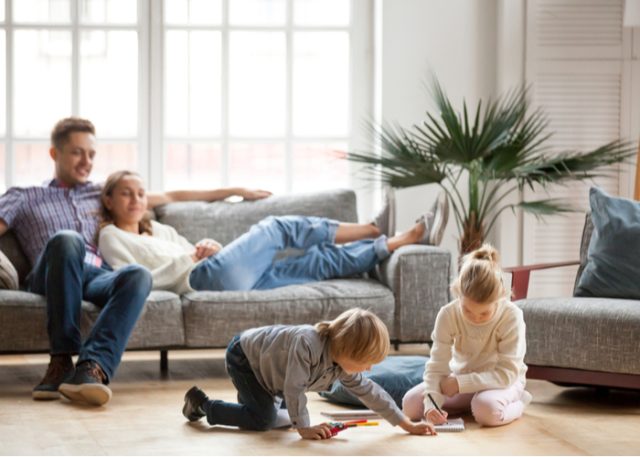 A family with young children in the living room of their home. 