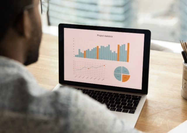 A man reviewing a financial graph on a computer.