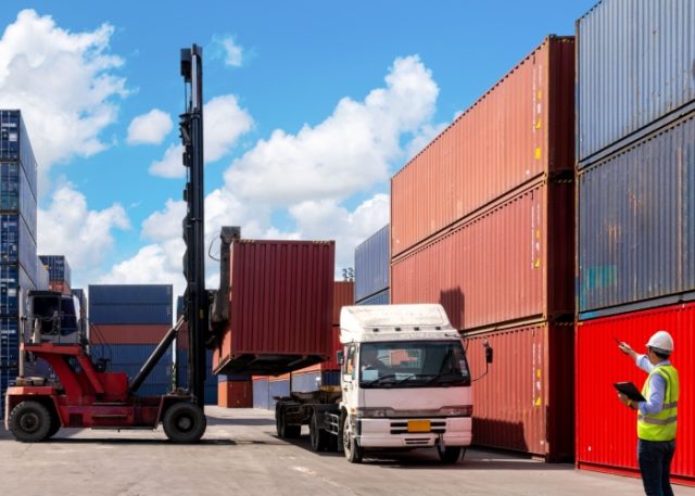 A foreman organising containers from a cargo ship.