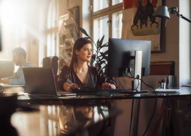 A woman using a computer in an office.