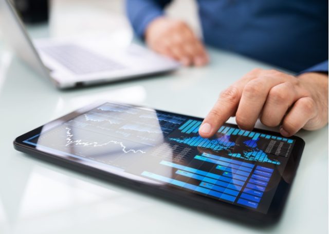 A man looking at graphs on a tablet.