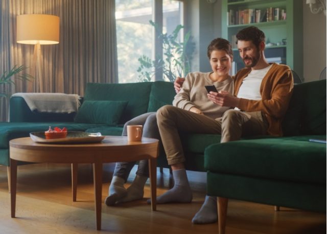 A couple sitting together in their living room.