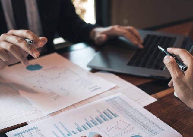Two people analysing statistical reports.
