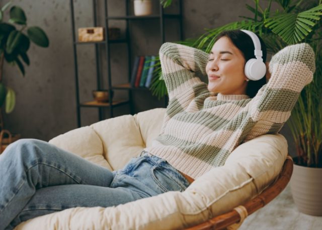 A woman relaxing with headphones on.