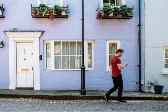 A man walking in front of a terraced house.