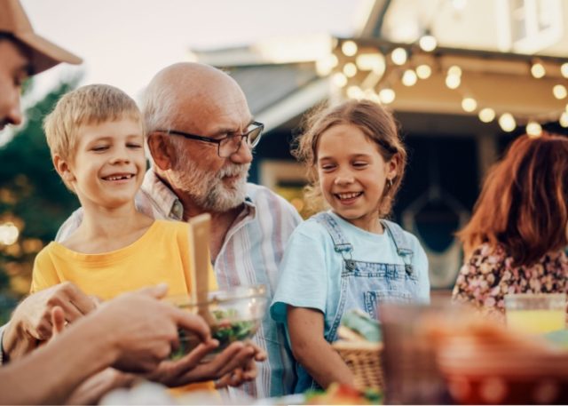 A grandfather laughing with his grandchildren.