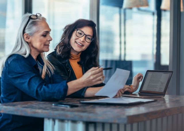 A woman talking to a colleague in an office.