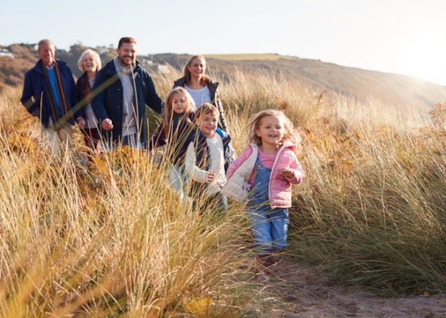 A family walking through dunes.